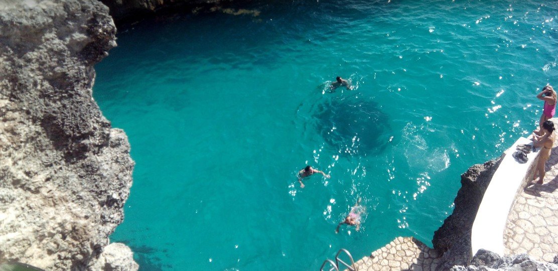 Swimmers in the turquoise cove below the cliffs at Rick's Café, Negril
